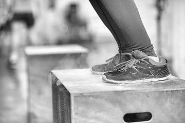 Image showing black woman is performing box jumps at gym