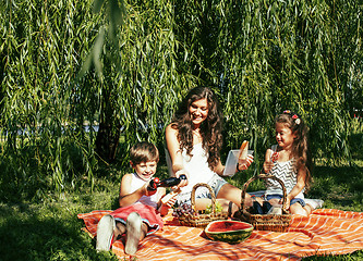 Image showing cute happy family on picnic laying on green grass mother and kid