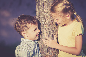 Image showing Two happy children  playing near the tree at the day time.