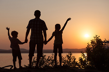 Image showing father and children playing on the coast of lake