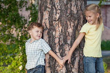 Image showing Two happy children  playing near the tree at the day time.