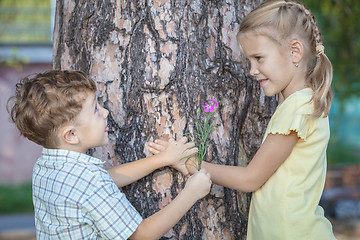 Image showing Two happy children  playing near the tree at the day time.