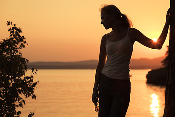 Image showing Silhouette of woman who standing on the coast of lake