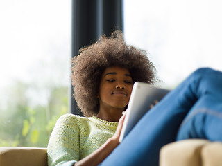 Image showing young african american woman at home using digital tablet