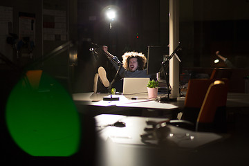 Image showing businessman sitting with legs on desk at office