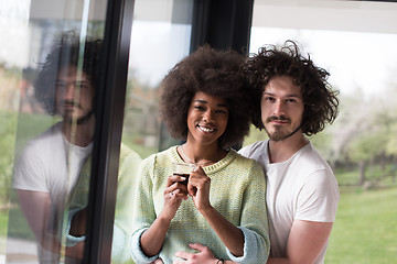 Image showing happy multiethnic couple relaxing at modern home indoors