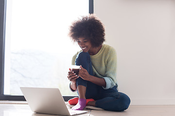 Image showing black woman in the living room on the floor