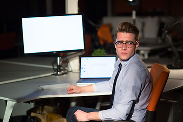 Image showing man working on computer in dark office