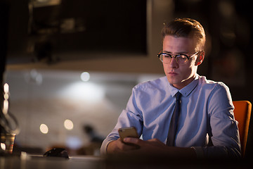 Image showing man using mobile phone in dark office