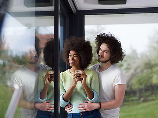 Image showing happy multiethnic couple relaxing at modern home indoors