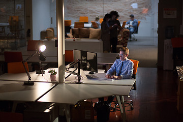 Image showing man working on computer in dark office