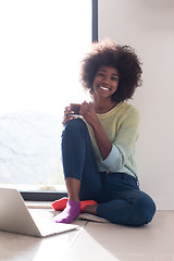 Image showing black woman in the living room on the floor