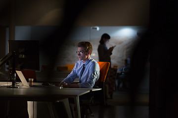 Image showing man working on computer in dark office