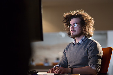 Image showing man working on computer in dark office