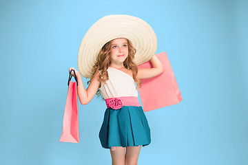 Image showing The cute little caucasian brunette girl in dress holding shopping bags