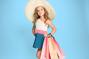 Image showing The cute little caucasian brunette girl in dress holding shopping bags