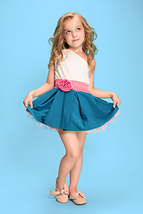 Image showing Full length of beautiful little girl in dress standing and posing over blue background