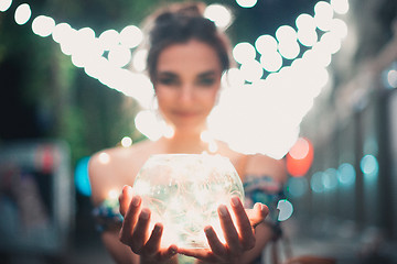 Image showing Beautiful young woman smiling and talking garlands of lights at city