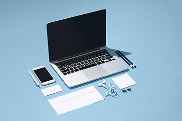 Image showing The laptop, pens, phone, note with blank screen on table