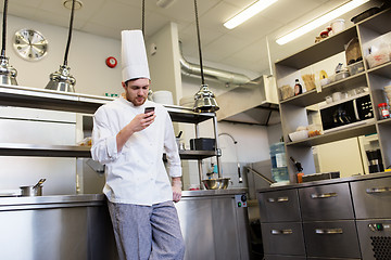 Image showing chef cook with smartphone at restaurant kitchen