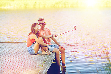 Image showing happy teenage couple taking selfie on smartphone