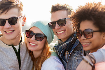 Image showing happy teenage friends in shades talking on street