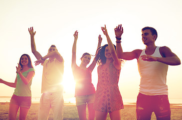 Image showing smiling friends dancing on summer beach