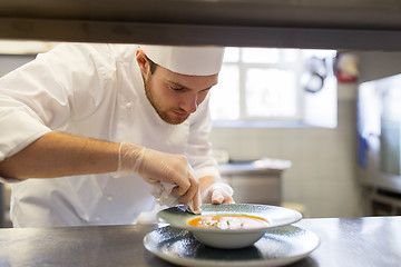 Image showing happy male chef cooking food at restaurant kitchen