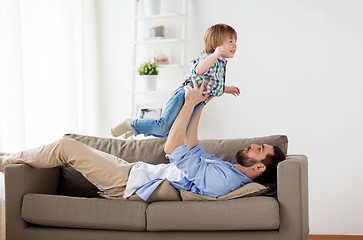 Image showing happy young father playing with little son at home