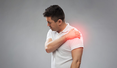 Image showing unhappy man suffering from pain in shoulder