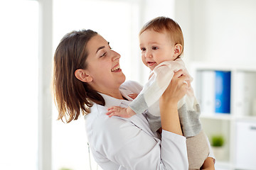 Image showing happy doctor or pediatrician with baby at clinic