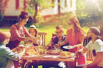 Image showing happy friends having dinner at summer garden party