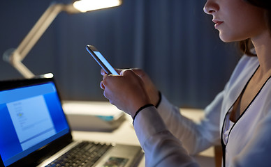 Image showing businesswoman with smartphone at night office