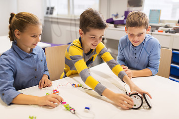 Image showing happy children building robots at robotics school