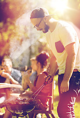 Image showing man cooking meat on barbecue grill at summer party