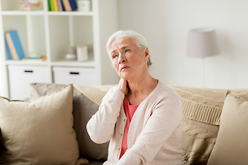 Image showing senior woman suffering from neck pain at home