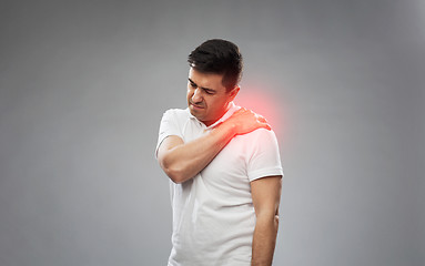 Image showing unhappy man suffering from pain in shoulder