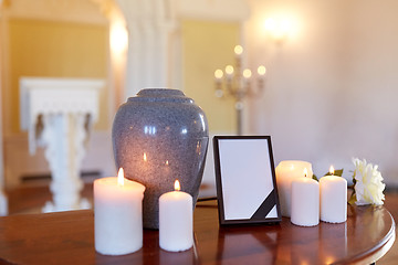 Image showing photo frame, cremation urn and candles in church