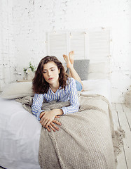 Image showing young pretty brunette woman in her bedroom sitting at window, happy smiling lifestyle people concept 