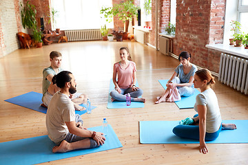 Image showing group of people resting on yoga mats at studio