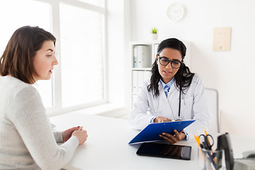 Image showing doctor with clipboard and woman patient at clinic