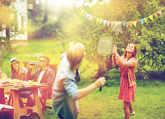 Image showing happy friends playing badminton at summer garden