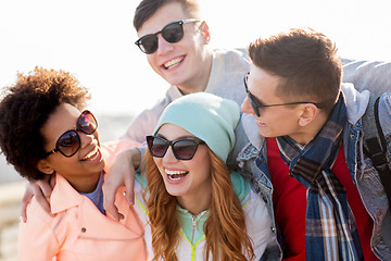 Image showing happy teenage friends in shades laughing outdoors