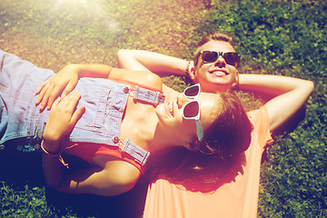 Image showing happy teenage couple lying on grass at summer