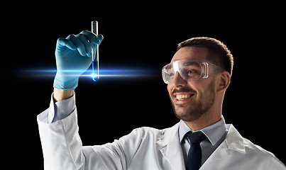 Image showing smiling scientist in goggles with test tube