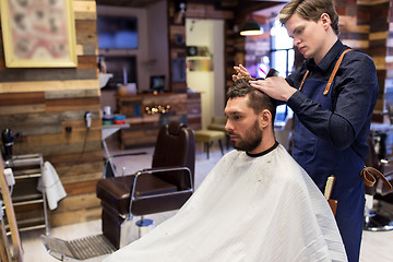 Image showing man and barber cutting hair at barbershop