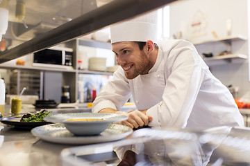 Image showing happy male chef cooking food at restaurant kitchen