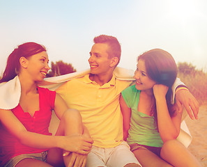 Image showing smiling friends in sunglasses on summer beach