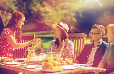 Image showing happy friends having dinner at summer garden party