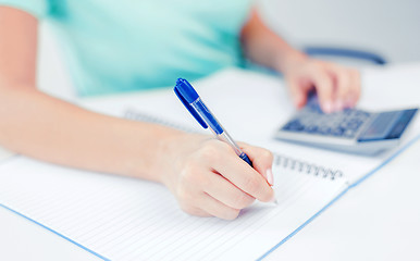 Image showing businesswoman working with calculator in office